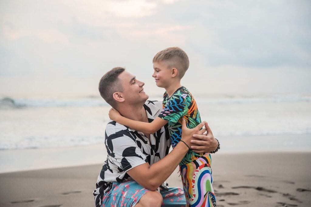Heartwarming moment of a father and son bonding at the beach, showcasing love and connection.