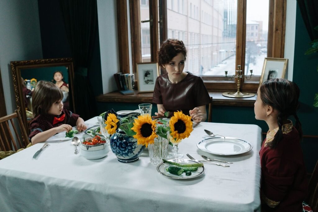 A family enjoying a meal indoors with sunflower centerpiece and window view.