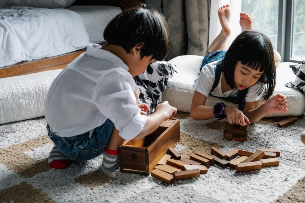 pexels-photo-5692641-5692641 Attentive Asian boy and girl playing with tower game while sitting on floor in cozy living room in apartment