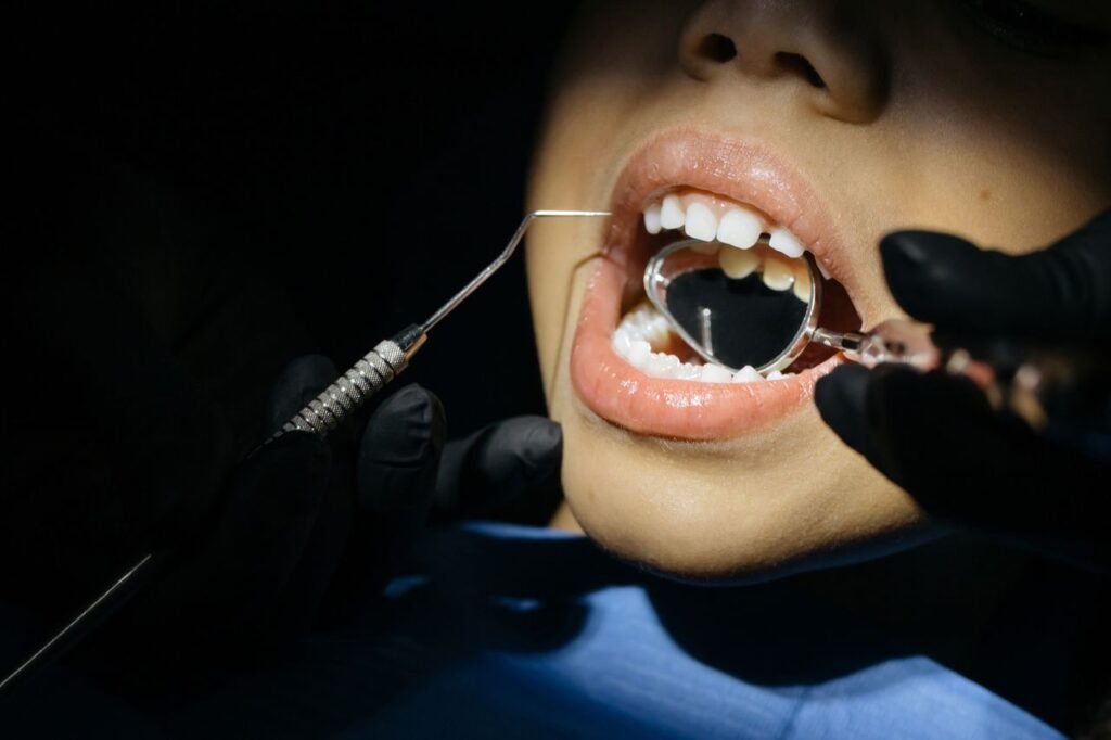 pexels-photo-6502542-6502542 A close-up view of a child undergoing a dental examination with tools in their mouth.