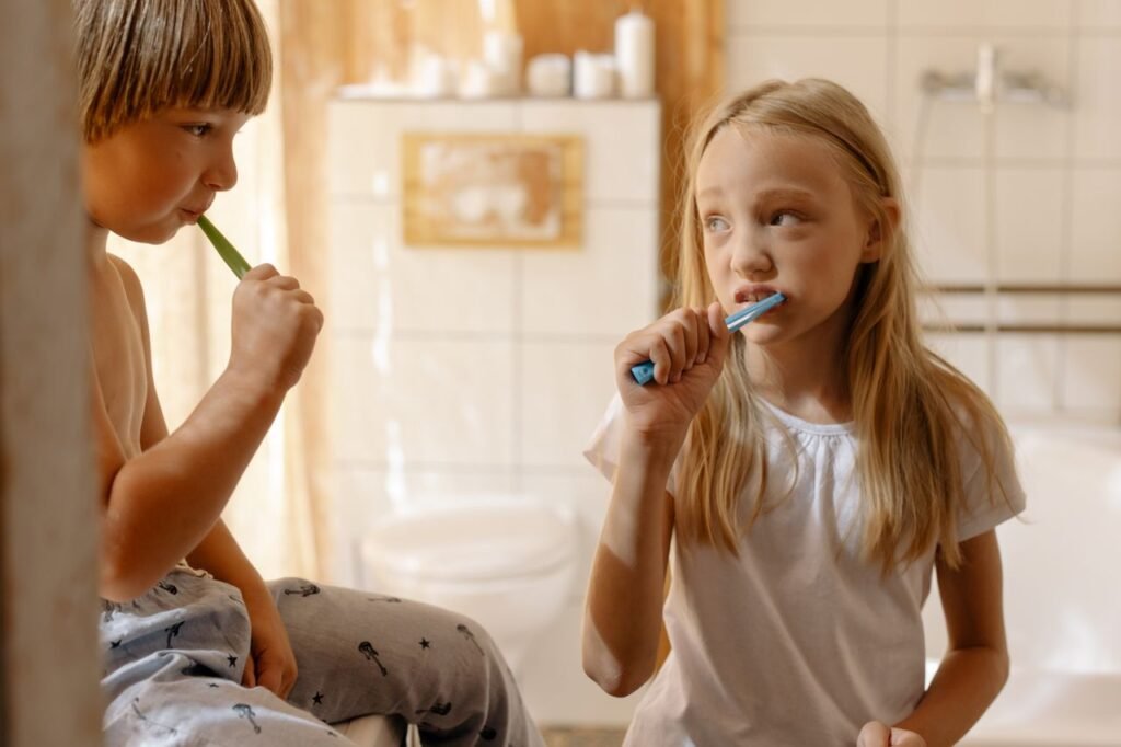 pexels-photo-7086238-7086238 Siblings brushing their teeth together in a cozy bathroom setting, promoting hygiene habits.