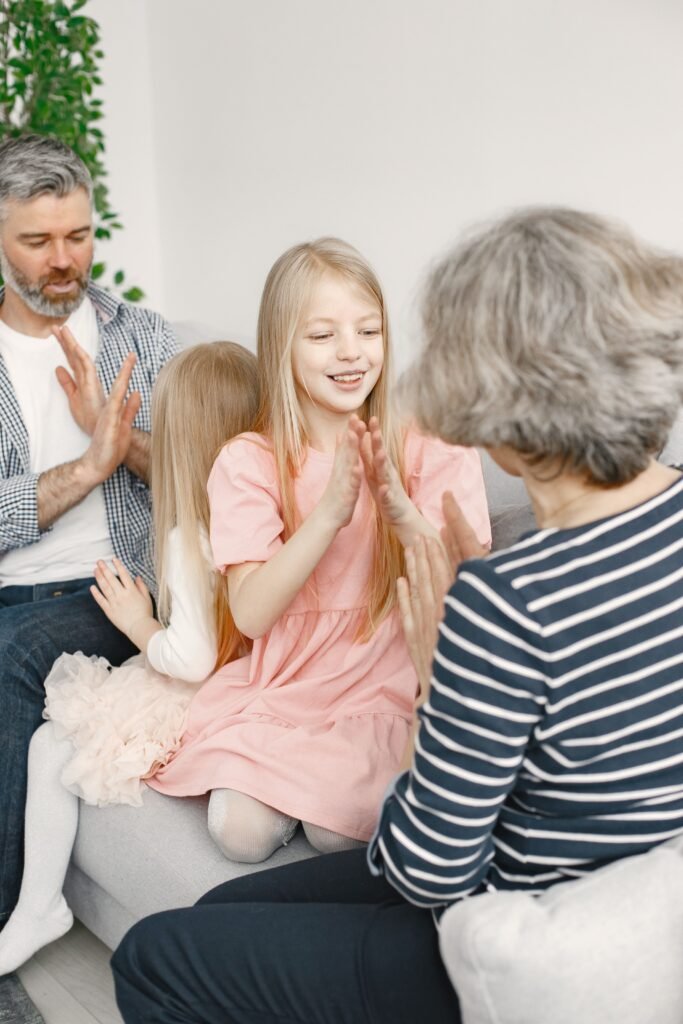 pexels-photo-7489082-7489082 Family enjoying a playful hand-clapping game together in a cozy home setting.